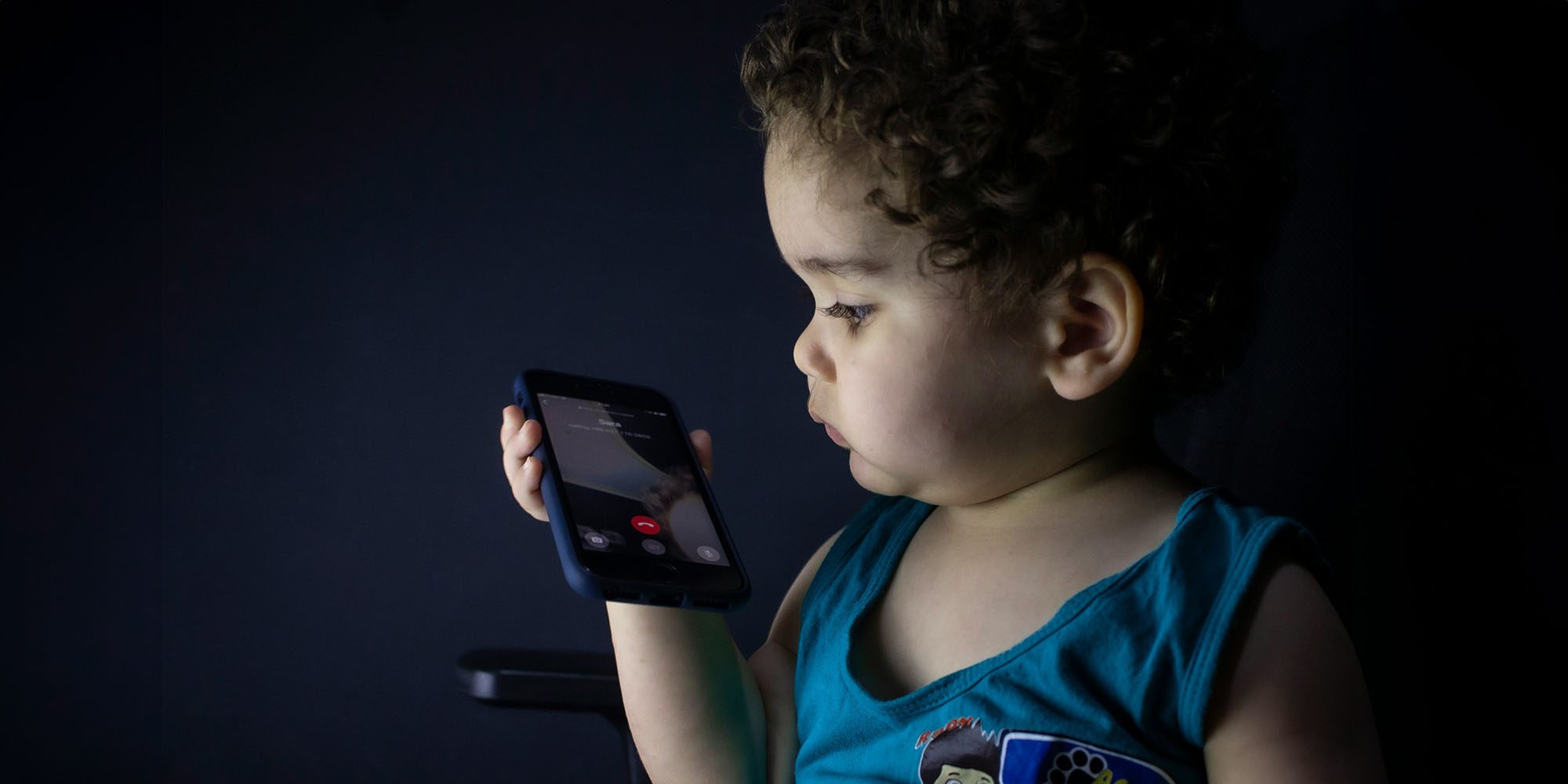 Apple must continue to age-verify users in Texas, says one-sentence ruling | Photo shows a very young child making a call on an iPhone