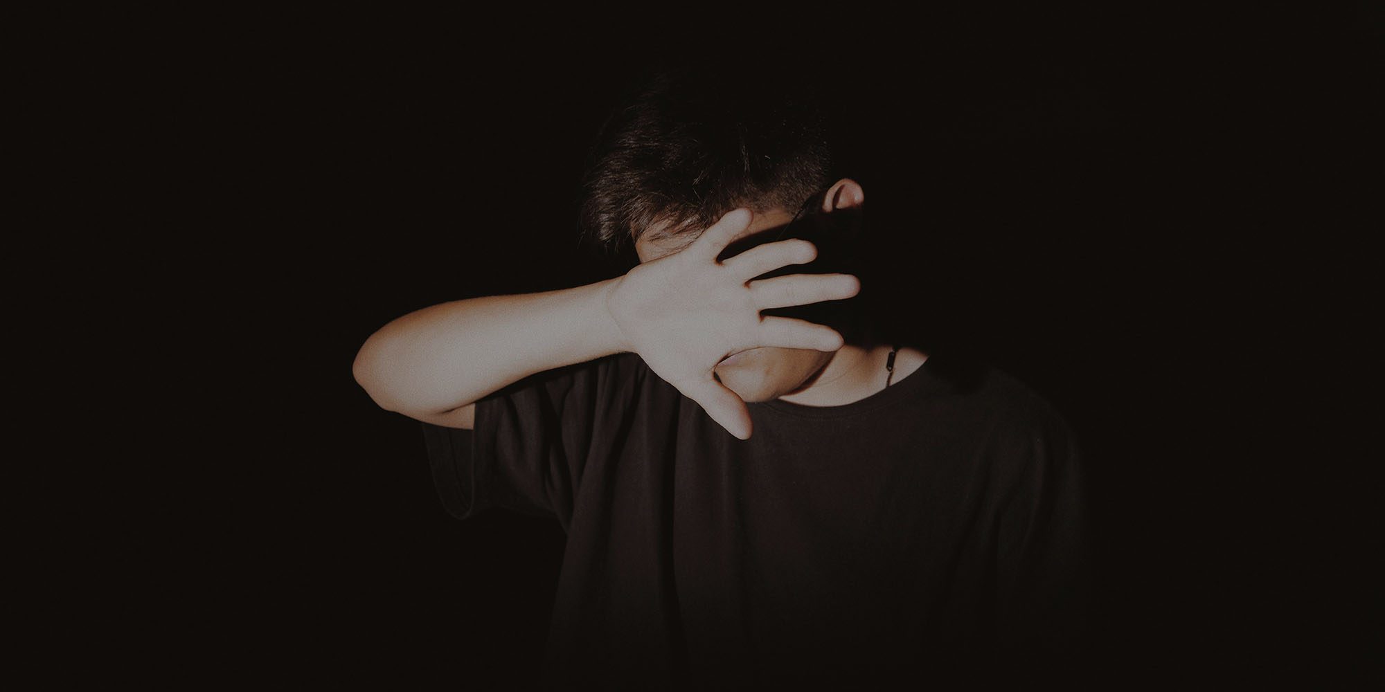 Safety regulator says Apple needs to do more to combat sextortion | Photo shows a teenage boy hiding his face